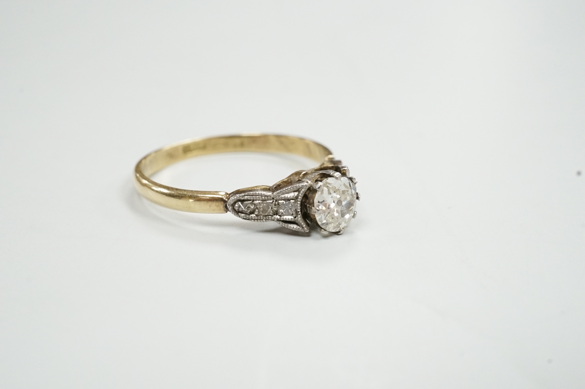 An 18ct and single stone diamond set ring, with diamond set shoulders, size N/O, gross weight 2.2 grams.
